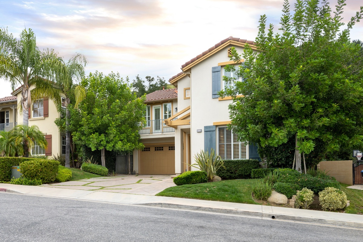 Two-story home with a garage and front-yard trees